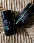Two lack deodorant sticks one with 'Só Fresh Extra-Strength Wild Balsam' and the other with 'Só Fresh Sensitive Wild Balsam' branding on a tan woven background