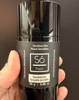 Black deodorant stick with 'Só Fresh Sensitive Skin Sandstorm' branding held by a hand against a dark background